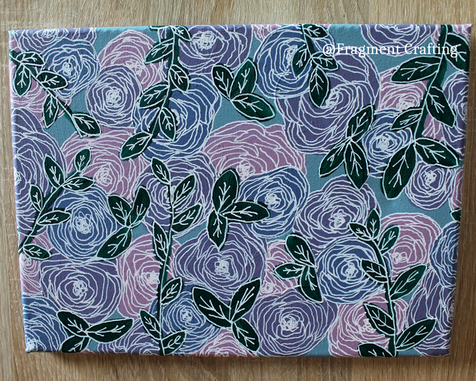 An original floral canvas of a teal background and pink and purple flowers.
