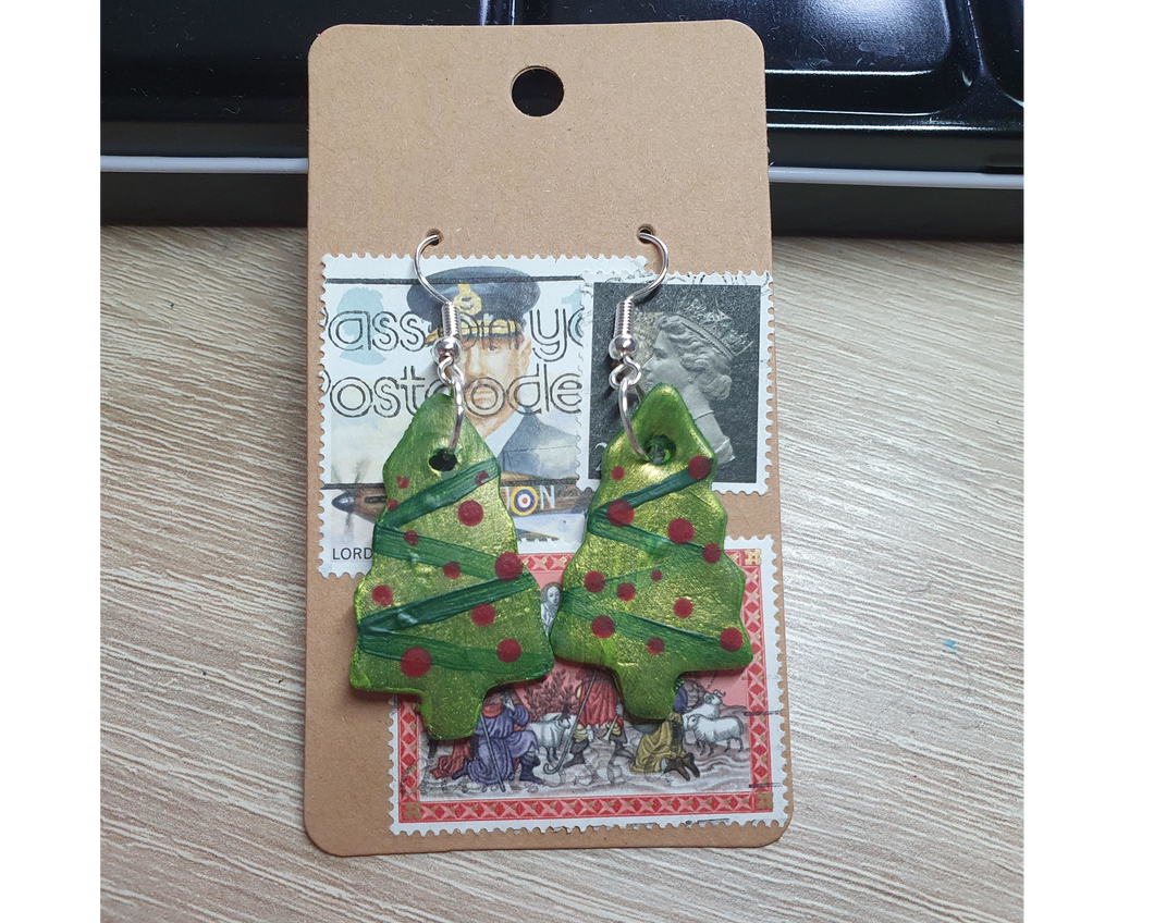 A pair of green Christmas tree earrings with red baubles.