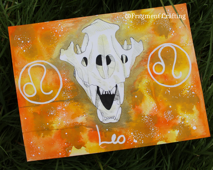 An original watercolour painting of a Leo star sign with a yellow and orange background and white skull of a lion being showed off on the grass.