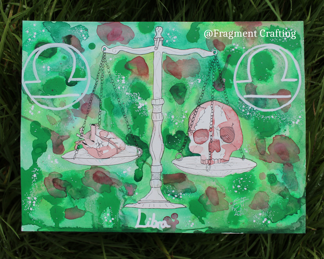 An original watercolour painting of a Libra star sign with various shades of green background and white set of scales with a skull one side and a heart on the other side of the scales being showed off on the grass.