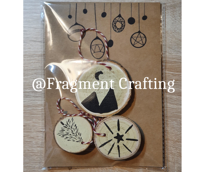 A pack of 3 wooden christmas decorations of a tree, star and mountains.