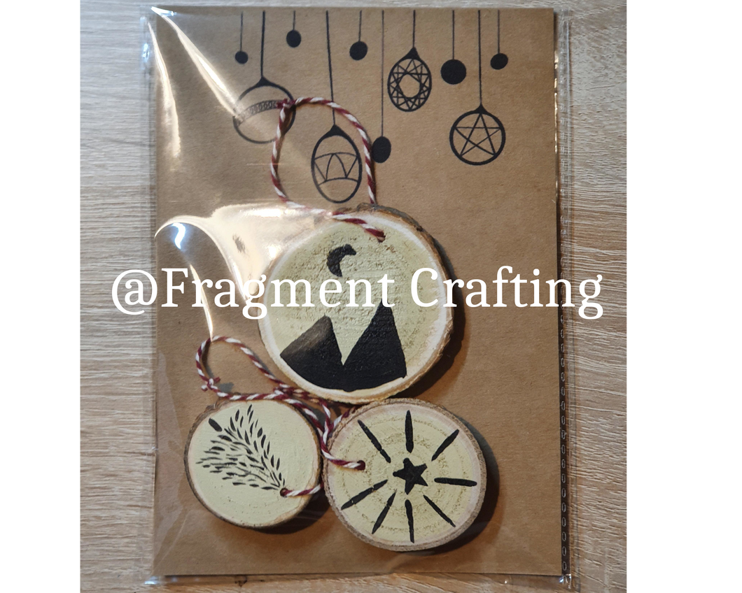 A pack of 3 wooden christmas decorations of a tree, star and mountains.