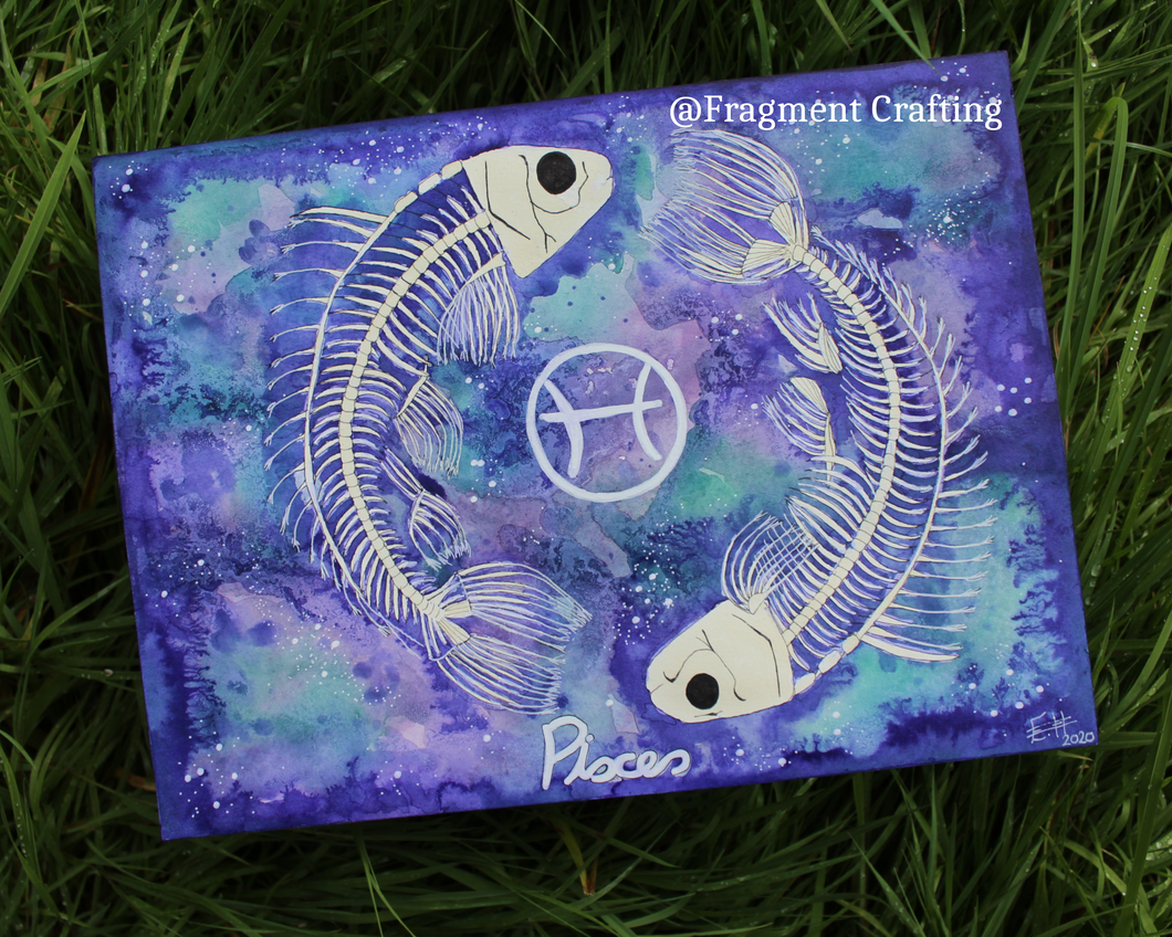 An original watercolour painting of Pisces star sign with a green and purple background and two white fish skeletons being showcased on the grass.