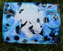 Load image into Gallery viewer, A print of a watercolour zodiac Sagittarius star sign of a white skull with arrows through on a blue background being showcased on the grass.
