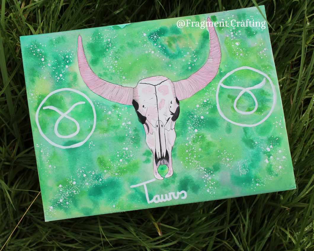 An original watercolour painting of a Taurus star sign with a green background and white skull of a bull being showcased on the grass.
