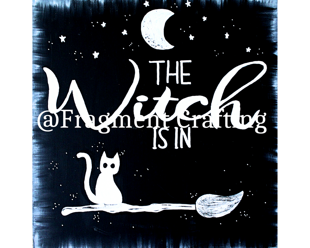A print copy of  a black background with white moon and stars and cat sitting on a broom with the title The Witch Is in.