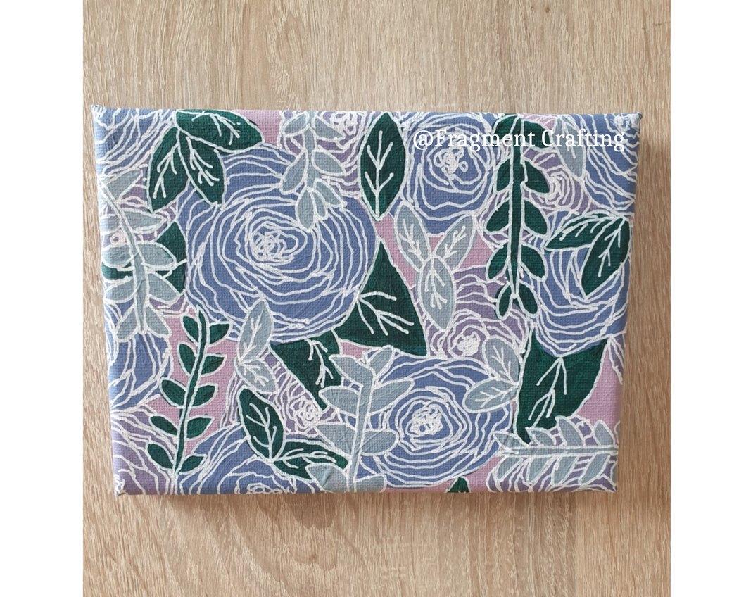 An acrylic floral canvas with a pink background, purple flowers and green leaves.