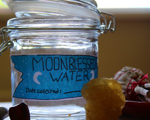 Load image into Gallery viewer, A blue moonblessed water sticker being showcased on a jar.

